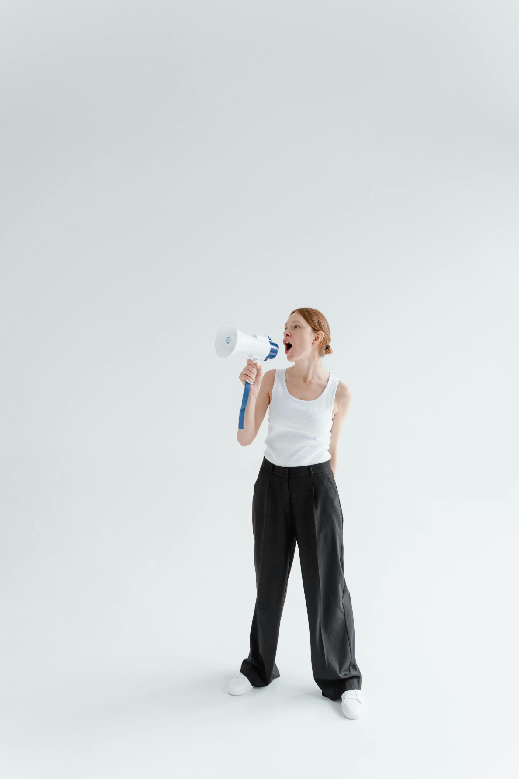 Photo by Tima Miroshnichenko: https://www.pexels.com/photo/a-woman-in-white-tank-top-and-black-pants-holding-a-megaphone-7202787/